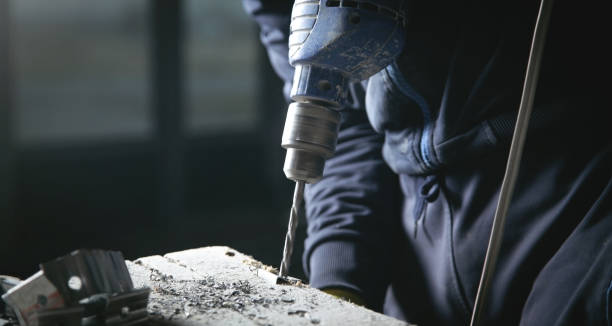 istock Master drills a hole in a metal. Industry 1345195771