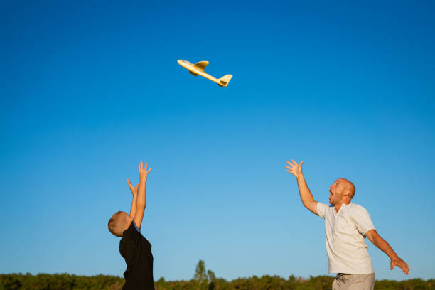 istock Dad and son play airplane in nature 1345197276