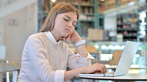 istock Exhausted Professional Woman Sleeping in Cafe 1345198564