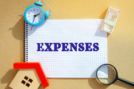 Notebook with the words Expenses. Outflow of money as payment for goods or service. The amount of the taxpayer's expenses in cash. Real estate expenses concept
