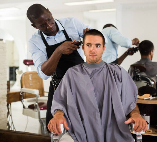 istock Man getting haircutting by African barber 1345199658