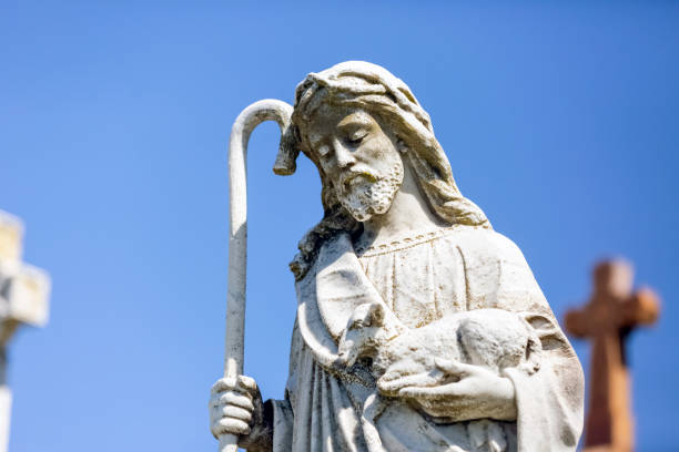 istock Old staue of St John The Baptist, blue sky background with copy space 1345204373