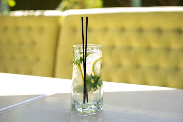 istock Glass of lemonade stands on white table outside. Refreshing summer drink 1345204525