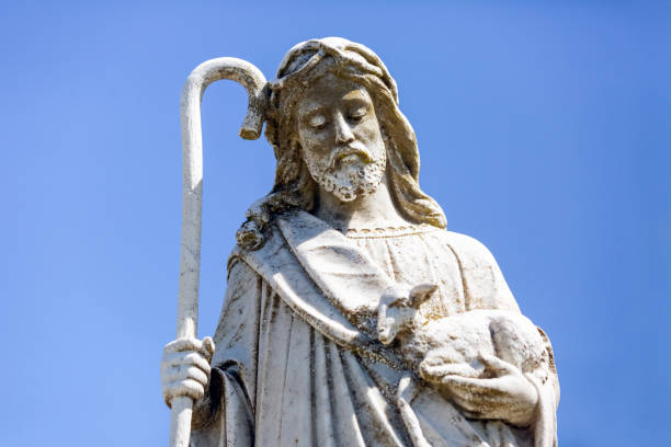 istock Old staue of St John The Baptist, front view, blue sky background with copy space 1345205829
