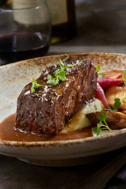 Red Wine Braised Boneless Short Rib with Black Truffle Au jus Red Wine Braised Boneless Short Rib  with King Oyster Mushrooms, Chive Mashed Potatoes and Black Truffle Au jus braised stock pictures, royalty-free photos & images