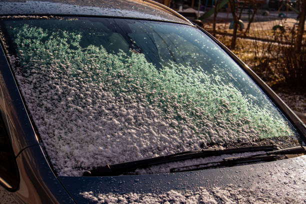 istock colored snow on a Sunny day, on a black car.late winter 1345208803