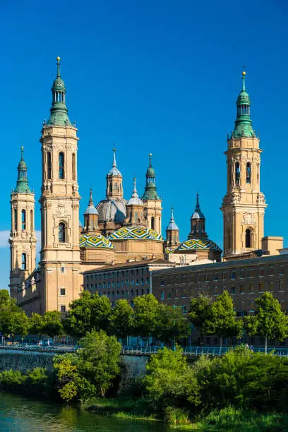 The Cathedral-Basilica of Our Lady of the Pillar along the Ebro river in Zaragoza, Spain on a sunny day.