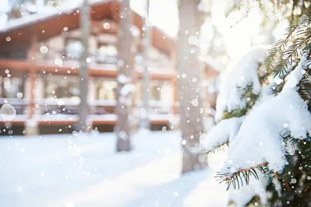 Photo of Winter background with a defocused country house. Snowfall. A place for the text