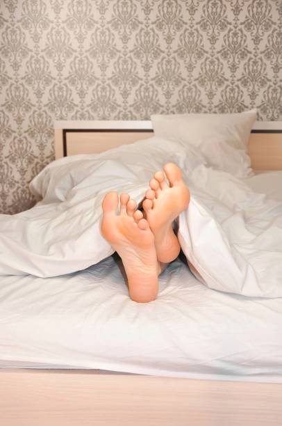 istock Woman's feet under the blanket in the morning 1345210966
