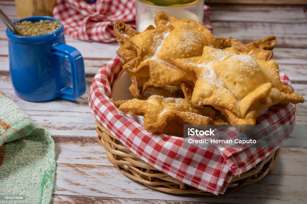 Typical fried sweet potato and quince pastries on a tray accompanied by the classic mate on an old wooden table. ethnic or regional cuisine concept. Typical fried sweet potato and quince pastries on a tray accompanied by the classic mate on an old wooden table. ethnic or regional cuisine concept. high view Baked Pastry Item Stock Photo