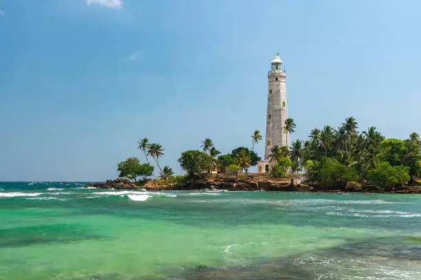 Photo of White lighthouse Dondra Head and tropical palms, Sri Lanka, near Matara