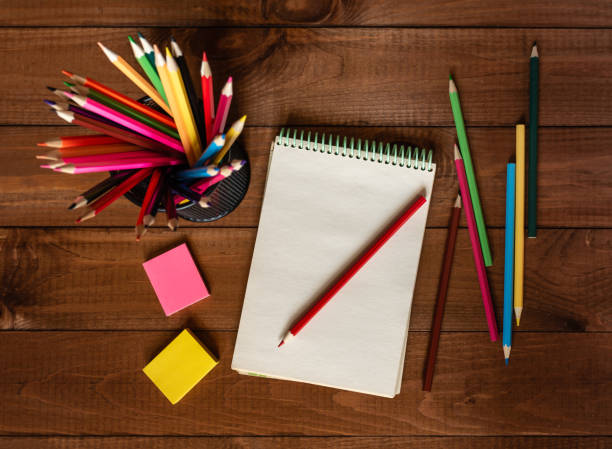 istock Open notebook with pencils in a concept of primary education, design, creativity or art 1345215968