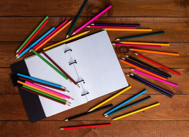 istock Open notebook with pencils in a concept of primary education, design, creativity or art 1345215977