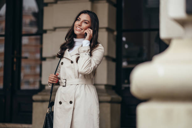 istock Beautiful young woman using a smartphone while out in the city 1345218010