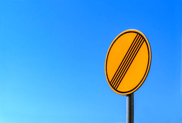 Bright yellow road sign against  bright blue sky. \n Road sign  made with retroreflective sheeting materials. Topic - road safety, road signs