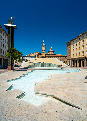 Zaragoza, Spain - July 30, 2021: The Fountain of Hispanicity (Fuente de la Hispanidad)  with the Iglesia de San Juan de los Panetes on the Plaza del Pilar in downtown Zaragoza, Spain.