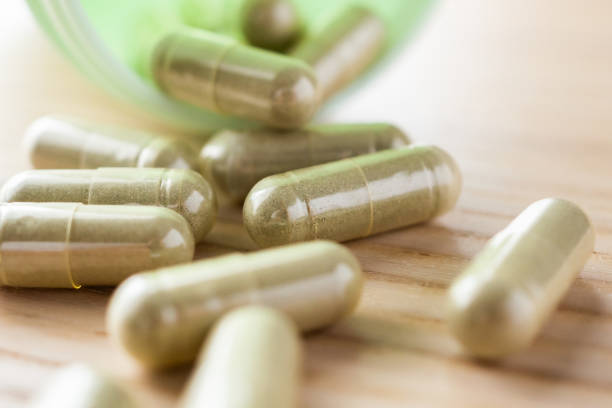 istock Herbal medicine capsules with bottle on wood table 1345227336