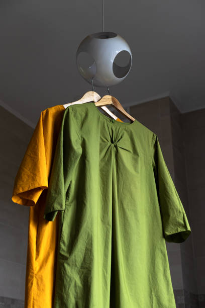 istock Ironed multicolored dresses hang from a round chandelier. Astronaut silhouette. 1345228023