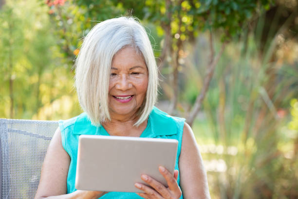 istock Senior Woman holding digital tablet in hands 1345229644