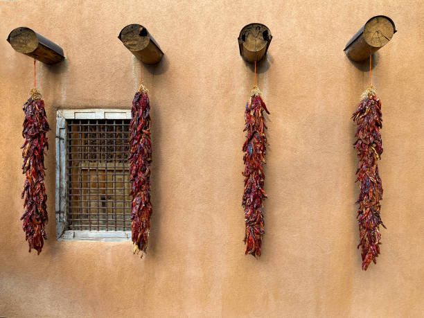 estilo santa fe: ristras de chile colgadas en la pared de adobe - ristra fotografías e imágenes de stock