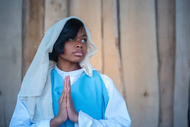 Photo of Black virgin mary representation praying in a crib