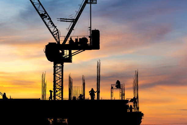 istock Silhouette of Engineer and worker with clipping path checking project at building site background, construction site at sunset in evening time 1345242368