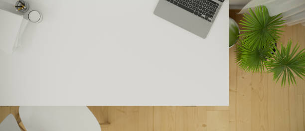 istock Top view of a white working desk with laptop computer and empty space for montage 1345246123