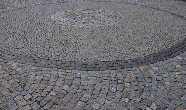 istock square with a large dark gray circle inside a small round of cobblestone cubes. the stone is granite and basalt. a court of honor where carriages or limousines turn in the historic center of the city 1345252964