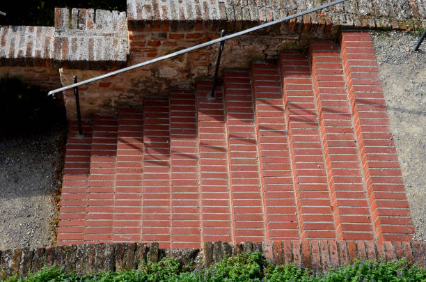 park schodów na tarasie włoskiego ogrodu. schody wykonane są z czerwonych cegieł przyklejonych do cementu. kuta metalowa balustrada na ścianie oporowej - brick wall paving stone brick wall zdjęcia i obrazy z banku zdjęć