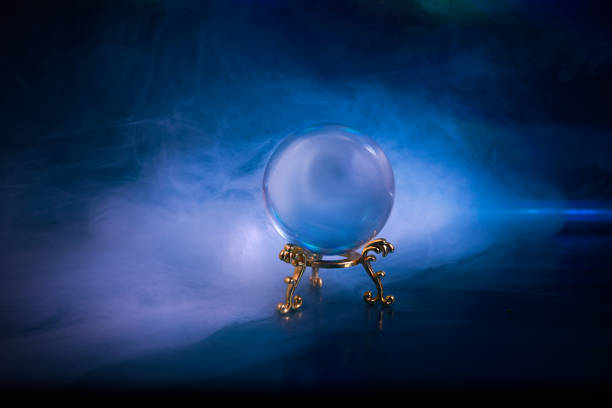 Crystal ball in a dark blue smoky background. Guessing for the future. Crystal ball in a dark blue smoky background. Guessing for the future fortune teller photos stock pictures, royalty-free photos & images