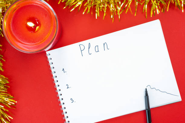 istock Drawing up a plan for the new year on a red Christmas background. 1345256876