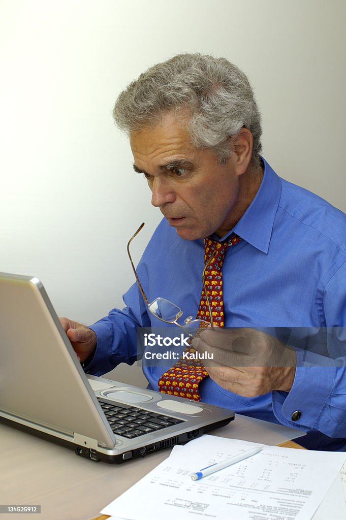 What's going on? A businessman looks at his laptop computer as though it's about to explode. Something has gone seriously wrong. 45-49 Years Stock Photo