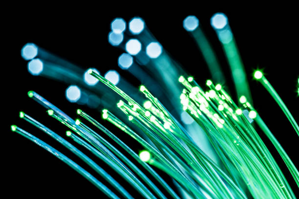 istock Bundle of optical fibers with green light. Black background. 1345260637