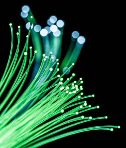 Bundle of optical fibers with green light. Black background.