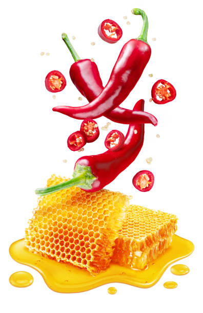 istock Fresh red chilli pepper and sections of chilli pepper floating over honeycombs and honey puddle isolated on white background. Clipping path 1345260748