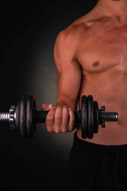 istock Young athlete holding his dumbbell with his right arm during his biceps routine. 1345261482