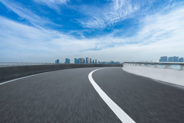 istock road through the bridge with city skyline background 1345266342
