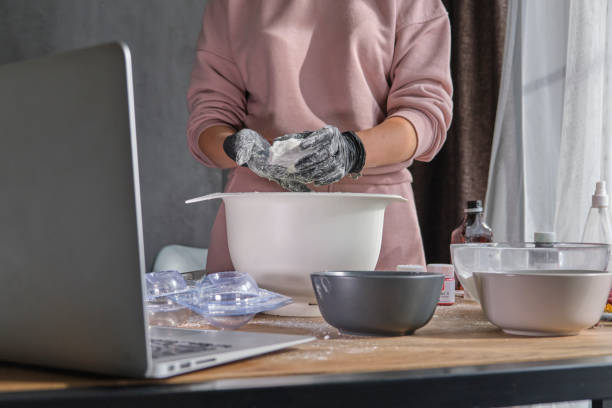istock woman is taking an online lesson or watching a video on creating bath bombs. Online training, online classes. master creates handmade cosmetics 1345267151