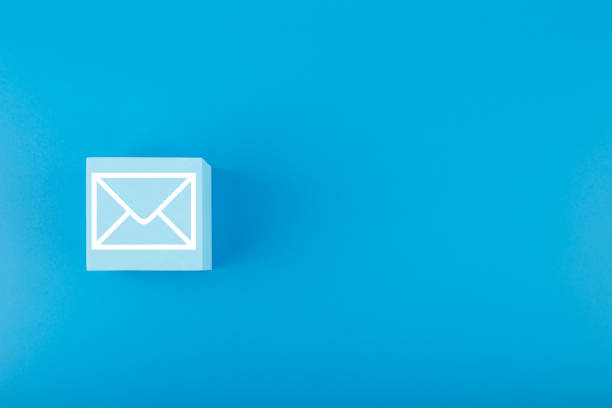 istock Email concept. Envelope drawn on toy square against blue background with copy space 1345267213