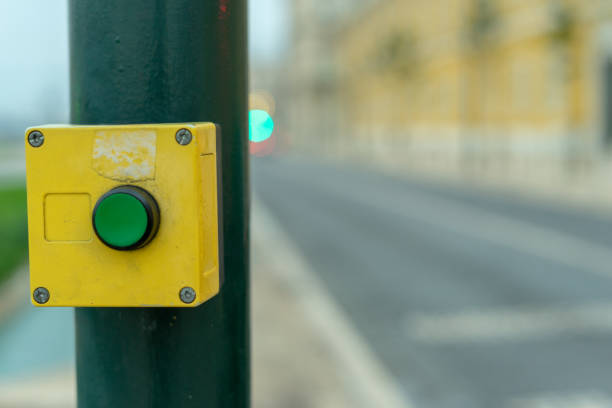 istock green button with yellow frame to stop traffic on crosswalk with blurred car traffic background 1345271632