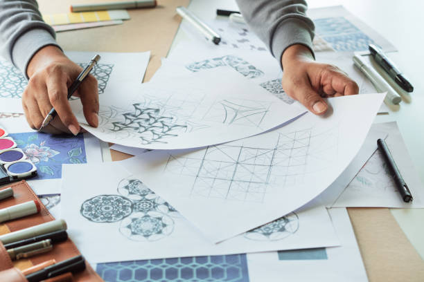 istock Designer designing drawing sketch pattern geometric flower seamless wallpaper fabric textile fashion industry. artistic design studio. 1345271814