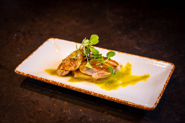 istock Fried tuna with sauce on a black background, on a white plate 1345272167
