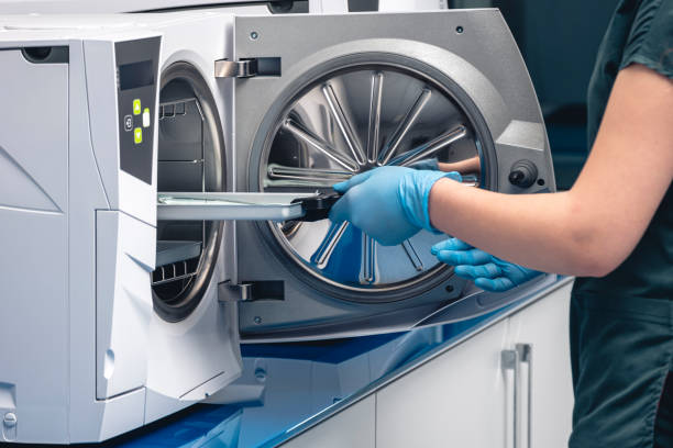 sterilizing medical instruments in autoclave. selective focus. dentist assistant's get out sterilizing medical instruments from autoclave. sterile dental tools - sterilizer imagens e fotografias de stock