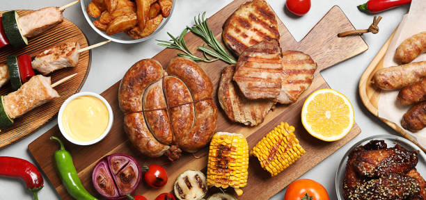 istock Flat lay composition with barbecued meat and vegetables on light table. Banner design 1345276770