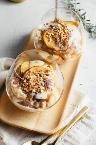 Parfait of baked apple ,custard, almond cookies and toasted almonds Christmas or autumn dessert in glasses made up of baked apple, crunchy almond cookies, custard, jam, yogurt, cinnamon, and toasted almonds. Parfait trifle stock pictures, royalty-free photos & images