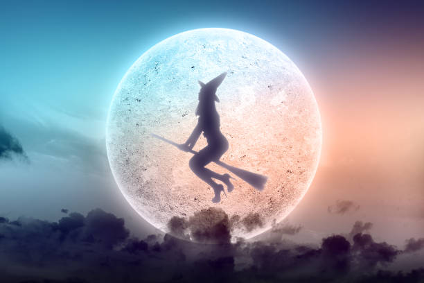 istock Silhouette of witch woman with a hat flying on a magic broomstick 1345278367