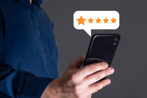 istock close up Man hand using smartphone with popup five star icon for feedback review satisfaction service. 1345278671