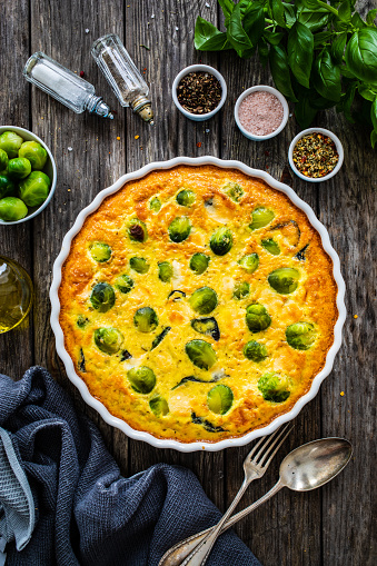 Millet quiche with brussels sprouts and ricotta on wooden table