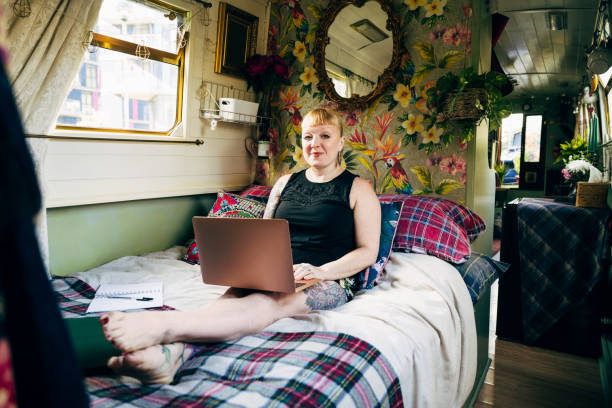 mittlere erwachsene weibliche londonerin entspannt mit laptop - narrow boat stock-fotos und bilder