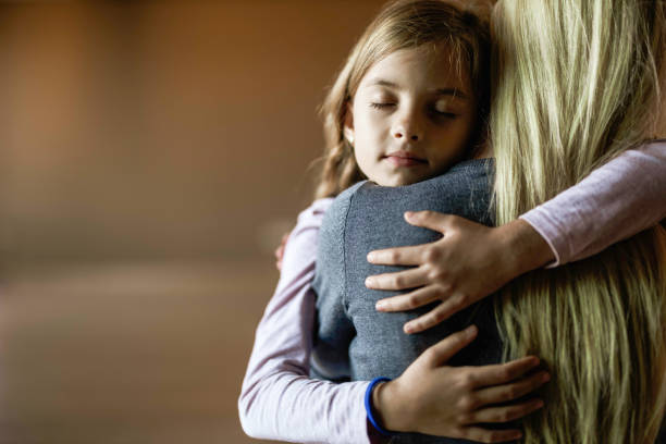 istock Affectionate little girl embracing her single mother at home. 1345284509